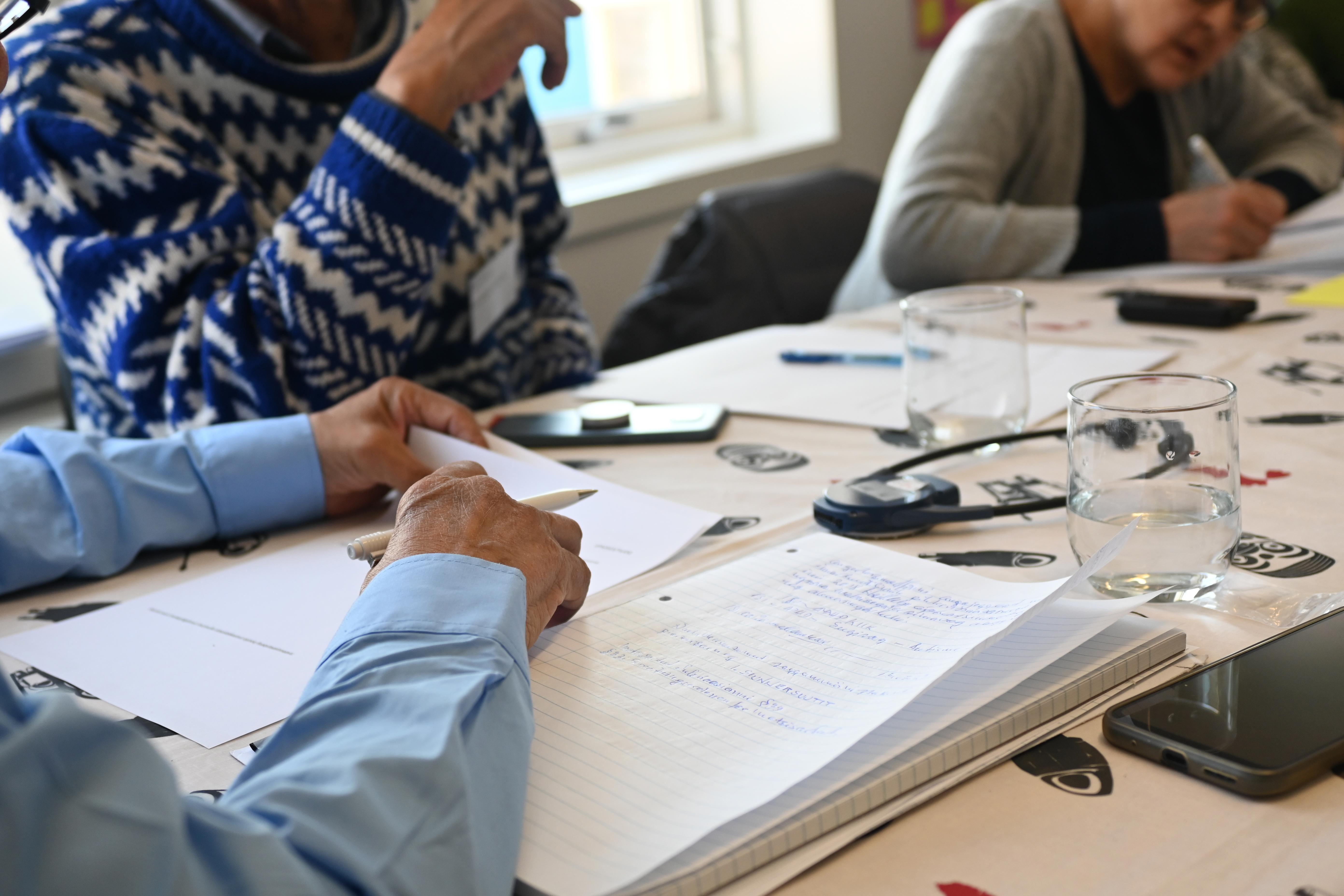 En mand med en notesbog foran sig til Tilioqs seminar 2023